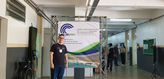 Picture of Johannes in front of a poster showing Induscon informations